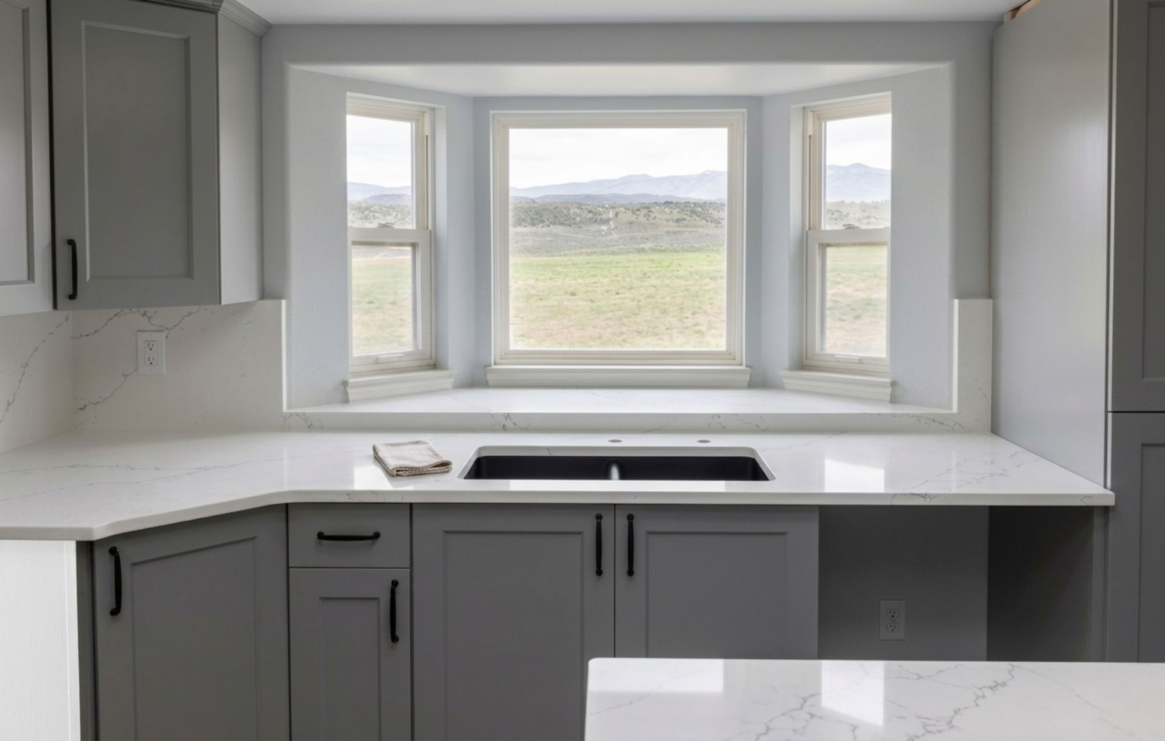 Finished kitchen with white veined quartz countertops, full backsplash and undermount sink