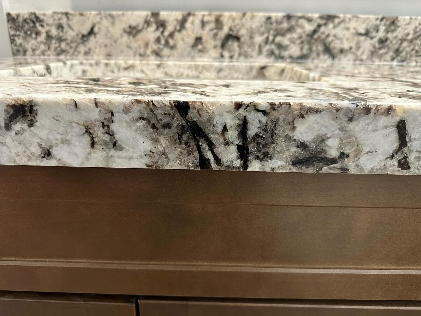 Close-up of a polished granite countertop edge restored by AK Granite